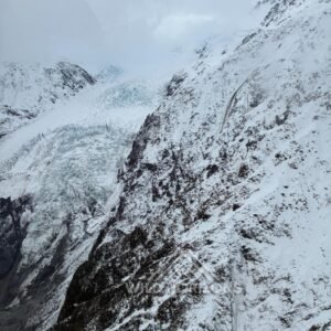 Snow-covered alpine icefall and glacier walls under cloud. Franz Josef Glacier, New Zealand