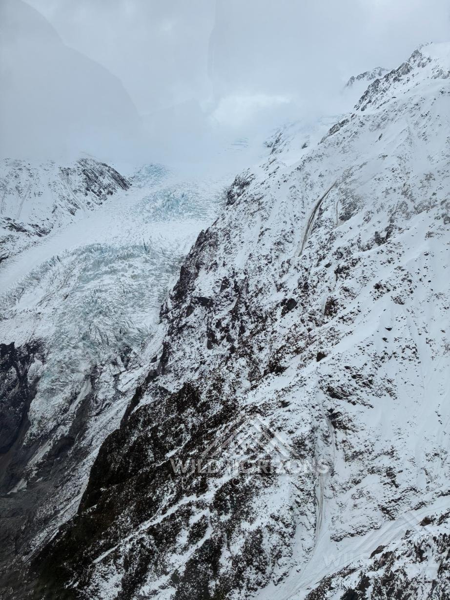 Snow-covered alpine icefall and glacier walls under cloud. Franz Josef Glacier, New Zealand