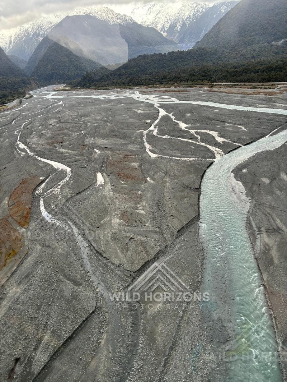 Braided glacial river carving wide alpine gravel flats. Franz Josef, New Zealand