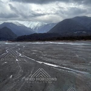 Wide alpine river flats beneath brooding mountain skies. Franz Josef, New Zealand