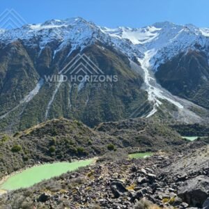 Glacial lakes beneath steep avalanche-carved alpine slopes. Aoraki / Mount Cook National Park, New Zealand