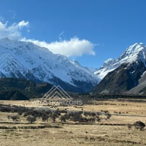 Broad alpine flats framed by towering snow-covered peaks. Aoraki / Mount Cook National Park, New Zealand