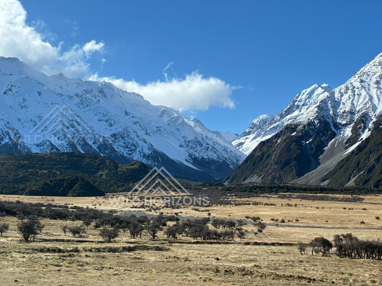 Broad alpine flats framed by towering snow-covered peaks. Aoraki / Mount Cook National Park, New Zealand