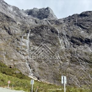 Waterfall and Mountain Cliffs Along Milford Road New Zealand