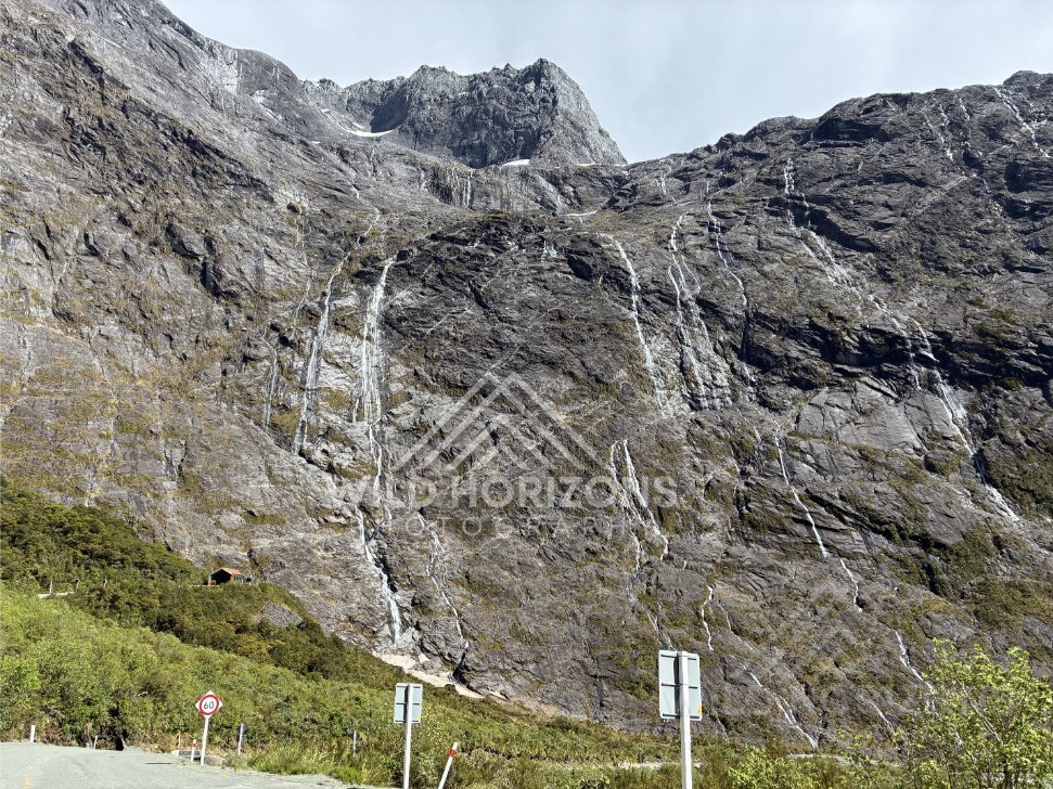 Waterfall and Mountain Cliffs Along Milford Road New Zealand