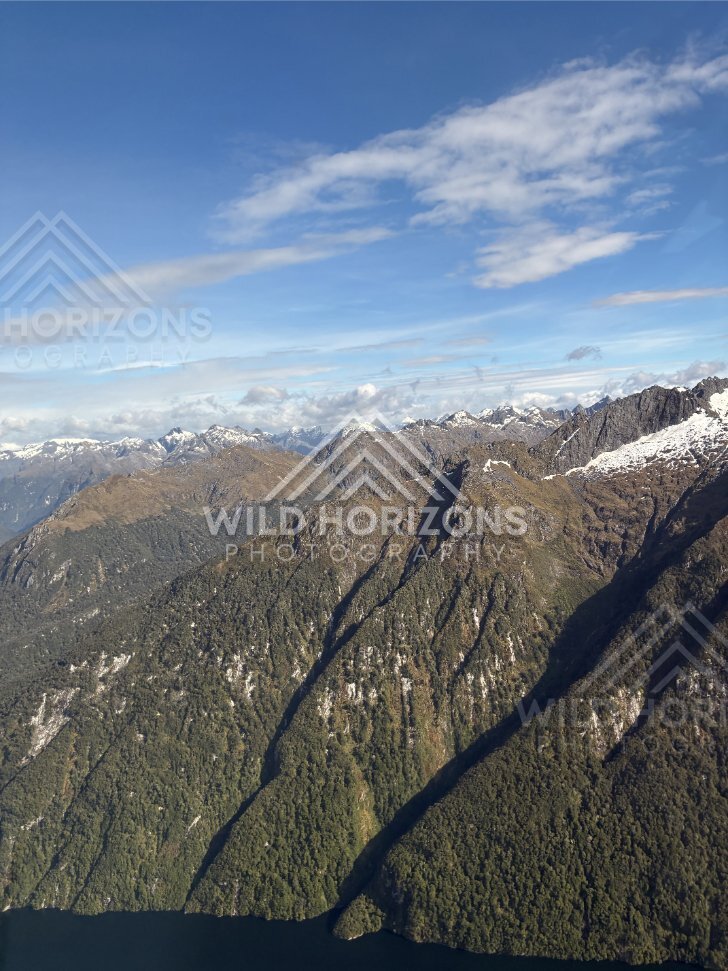 Aerial View of Forested Ridges and Snow-Dusted Peaks, Fiordland National Park, New Zealand