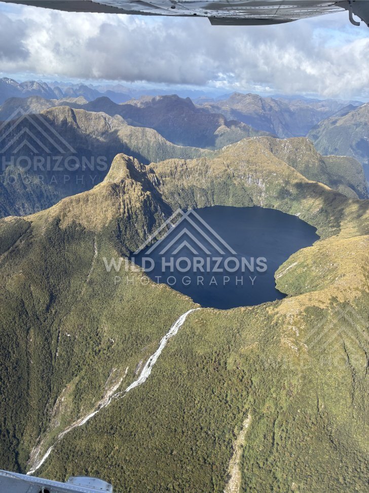 Aerial View of a Circular Mountain Lake and Stream, Fiordland National Park, New Zealand