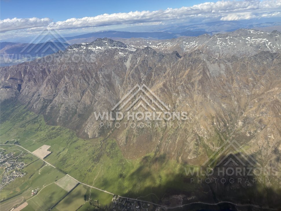 Aerial view of the jagged peaks of the Remarkables range under scattered cloud. The Remarkables, New Zealand