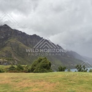 Low cloud and layered light reflected across the calm waters of Lake Te Anau. Lake Te Anau, New Zealand