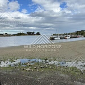 Boats Resting in a Quiet Estuary at Low Tide Under Layered Coastal Clouds. Riverton, New Zealand