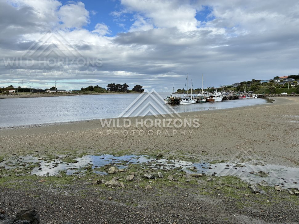Boats Resting in a Quiet Estuary at Low Tide Under Layered Coastal Clouds. Riverton, New Zealand