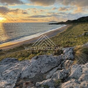 Warm Sunset Light Washing Over Coastal Rocks and a Sweeping Beachline. Riverton, New Zealand