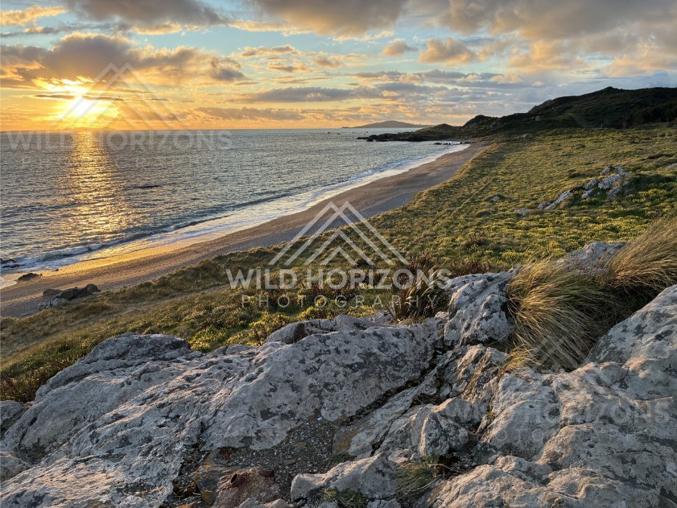 Warm Sunset Light Washing Over Coastal Rocks and a Sweeping Beachline. Riverton, New Zealand