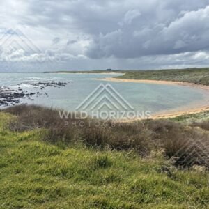 Sheltered turquoise bay with sandbar and coastal grasslands. Catlins Coast, New Zealand