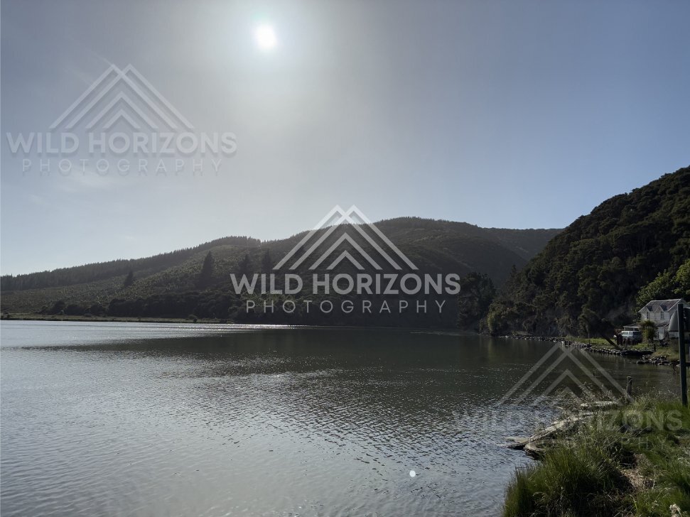 Wide Lake with Forested Hills and Distant Building, Taieri River, New Zealand