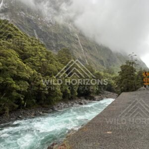Rain-swollen river beside roadside pull-off on Milford Road, New Zealand