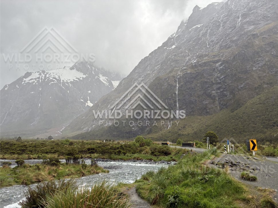 Mountain stream beside roadside markers on Milford Road, New Zealand