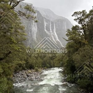 River corridor leading to towering waterfalls, Milford Road, New Zealand