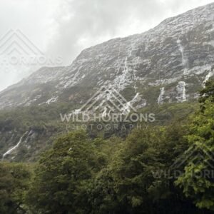 Thin waterfalls tracing a granite mountainside, Milford Road, New Zealand