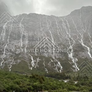 Milford Road beneath a wall of rain-fed waterfalls, New Zealand