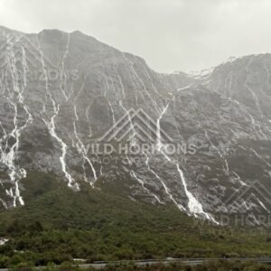 Snowy ridge and waterfalls above the Milford Road, New Zealand