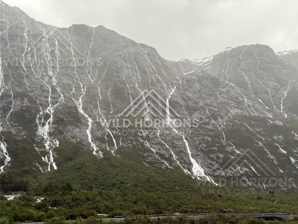Snowy ridge and waterfalls above the Milford Road, New Zealand