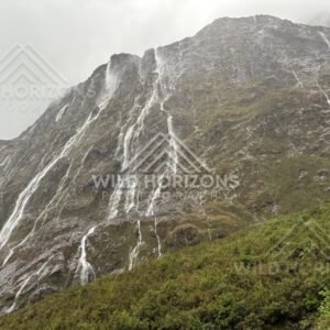 Steep Fiordland escarpment with multiple waterfalls, Milford Road, New Zealand