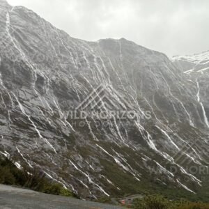 Waterfall-streaked mountains and winding road, Milford Road, New Zealand