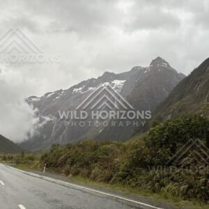 Empty wet highway through a Fiordland valley, Milford Road, New Zealand