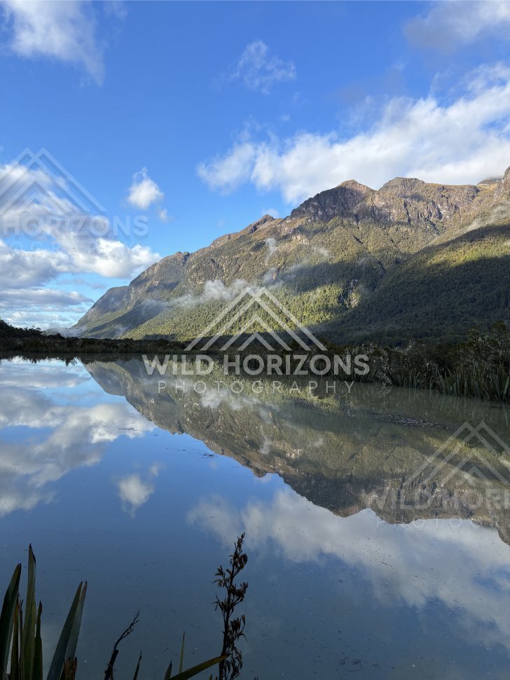 Long Mirror-Like Reflection Toward Distant Slopes, Milford Road, New Zealand