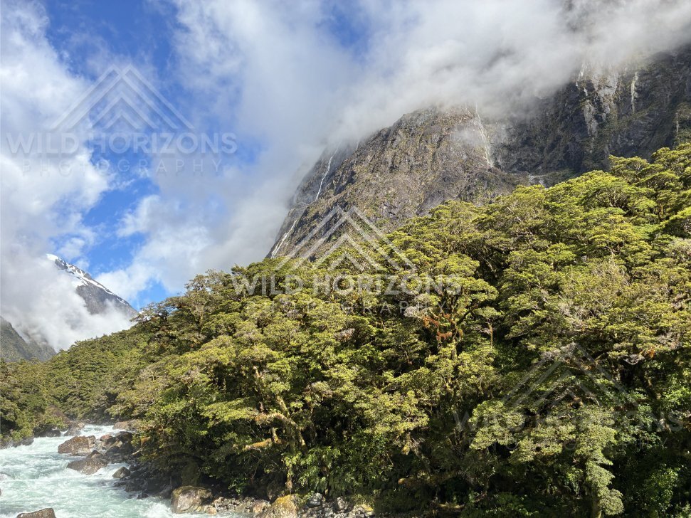 Cloud bands drifting across rugged mountain faces, Milford Road, New Zealand