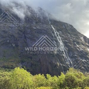 Sunlit Fiordland Waterfall on a Slanted Rock Face, Milford Road, Fiordland National Park, New Zealand