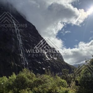 Waterfall and Sunburst over Fiordland Mountains, Milford Road, Fiordland National Park, New Zealand