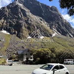 Mountain Lodge and Car beneath a Massive Fiordland Peak, Milford Road, Fiordland National Park, New Zealand
