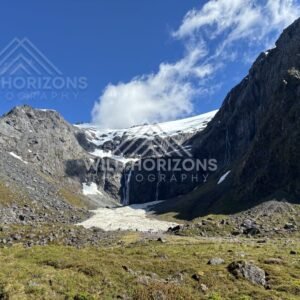 Alpine Cirque Waterfall below a Snowfield in Fiordland, Milford Road, Fiordland National Park, New Zealand