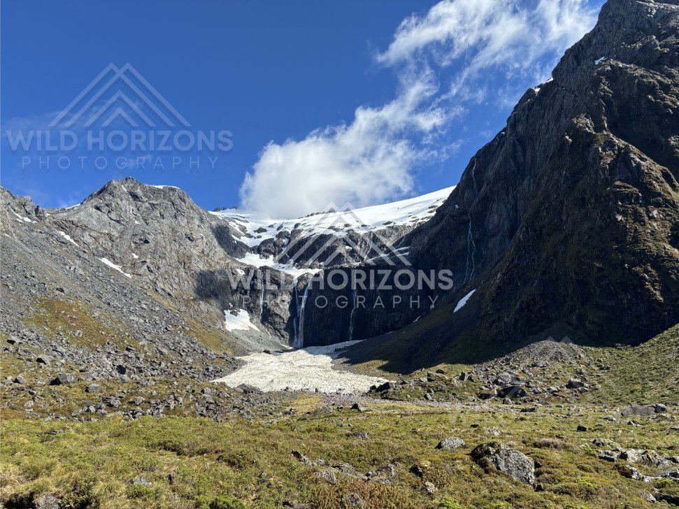 Alpine Cirque Waterfall below a Snowfield in Fiordland, Milford Road, Fiordland National Park, New Zealand