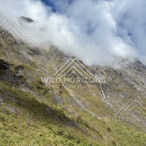 Dramatic Cloud Edge over a Sunlit Fiordland Slope, Milford Road, Fiordland National Park, New Zealand