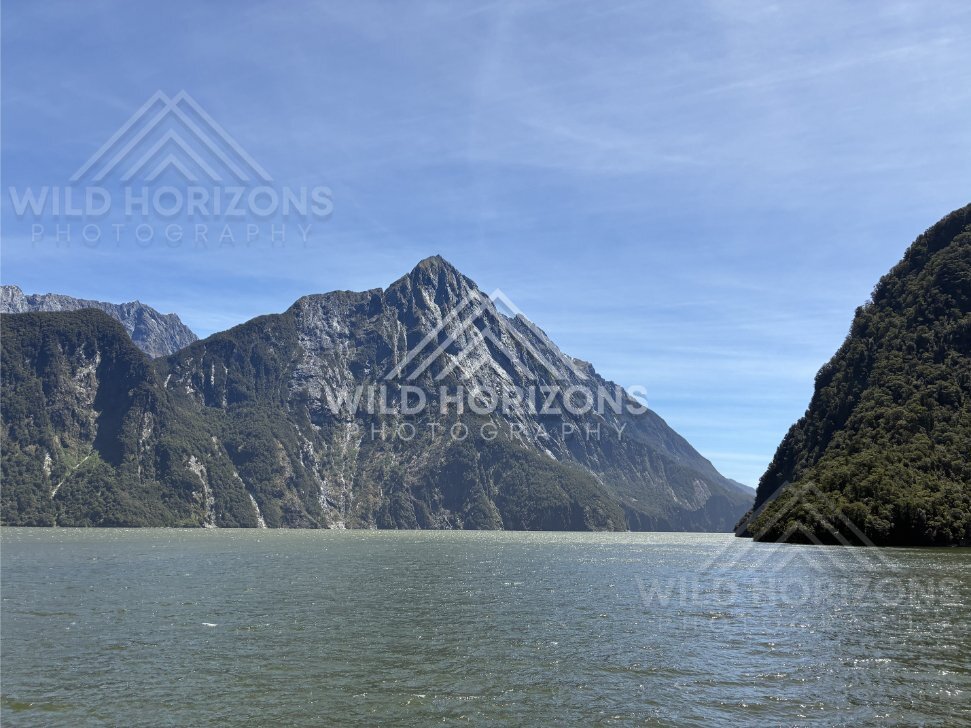Jagged peak above calm fjord waters, Milford Sound, New Zealand