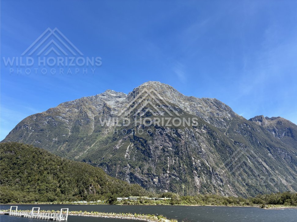 Mountain rising above Milford Sound marina and jetty, New Zealand