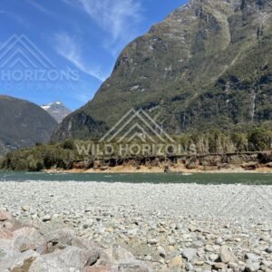 Boulder riverbed beneath steep Fiordland slopes, Milford Road, New Zealand