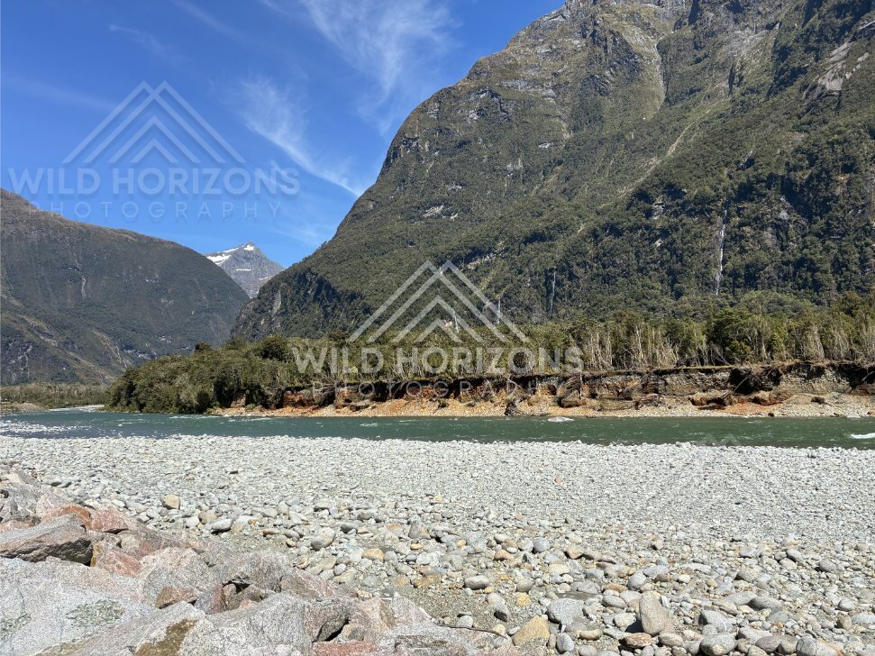 Boulder riverbed beneath steep Fiordland slopes, Milford Road, New Zealand
