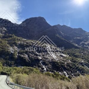 Mountain Road Curving Beneath Steep Rocky Slopes. New Zealand