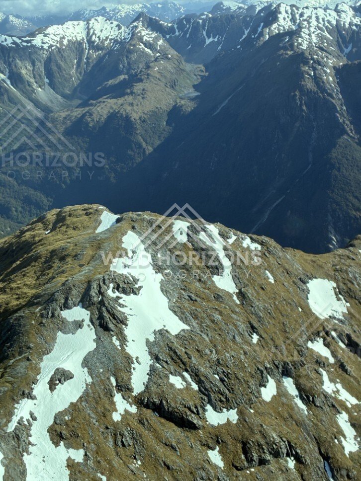 Steep Fiordland Cliffs and Snow Streaks. Fiordland, New Zealand.