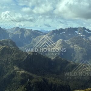 Layered mountain ranges beneath broken cloud. Fiordland, New Zealand.
