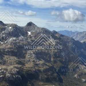 Rocky alpine peaks beneath sweeping cloud. Fiordland, New Zealand.