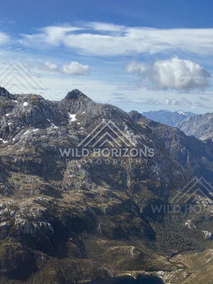 Rocky alpine peaks beneath sweeping cloud. Fiordland, New Zealand.