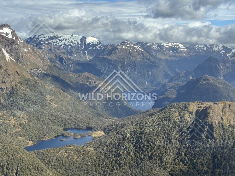 Long Fiordland lake winding through forested valleys. Fiordland, New Zealand.