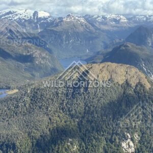 Sunlit ridgelines above layered Fiordland lakes. Fiordland, New Zealand.