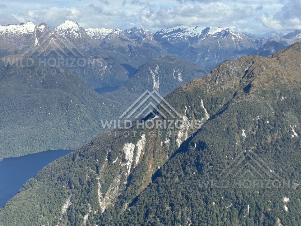 Mountain ridges above a long Fiordland lake. Fiordland, New Zealand.