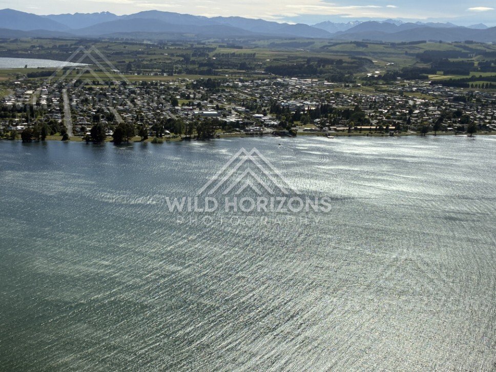 Wind-textured lake surface and lakeside settlement. Manapouri, New Zealand.